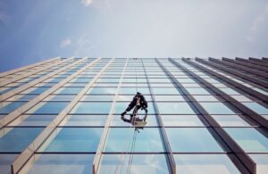 Window cleaner is working on the office building facade