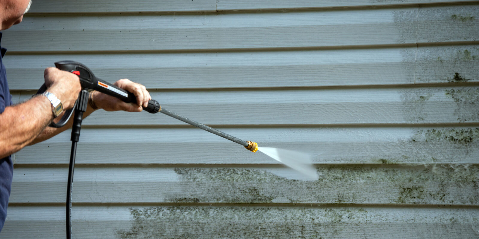 An,Unidentified,Man,Uses,A,Power,Washer,To,Clean,Mold Sparkling Clean Exterior